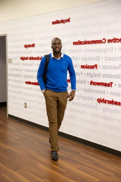 student walking in Richards College of Business.