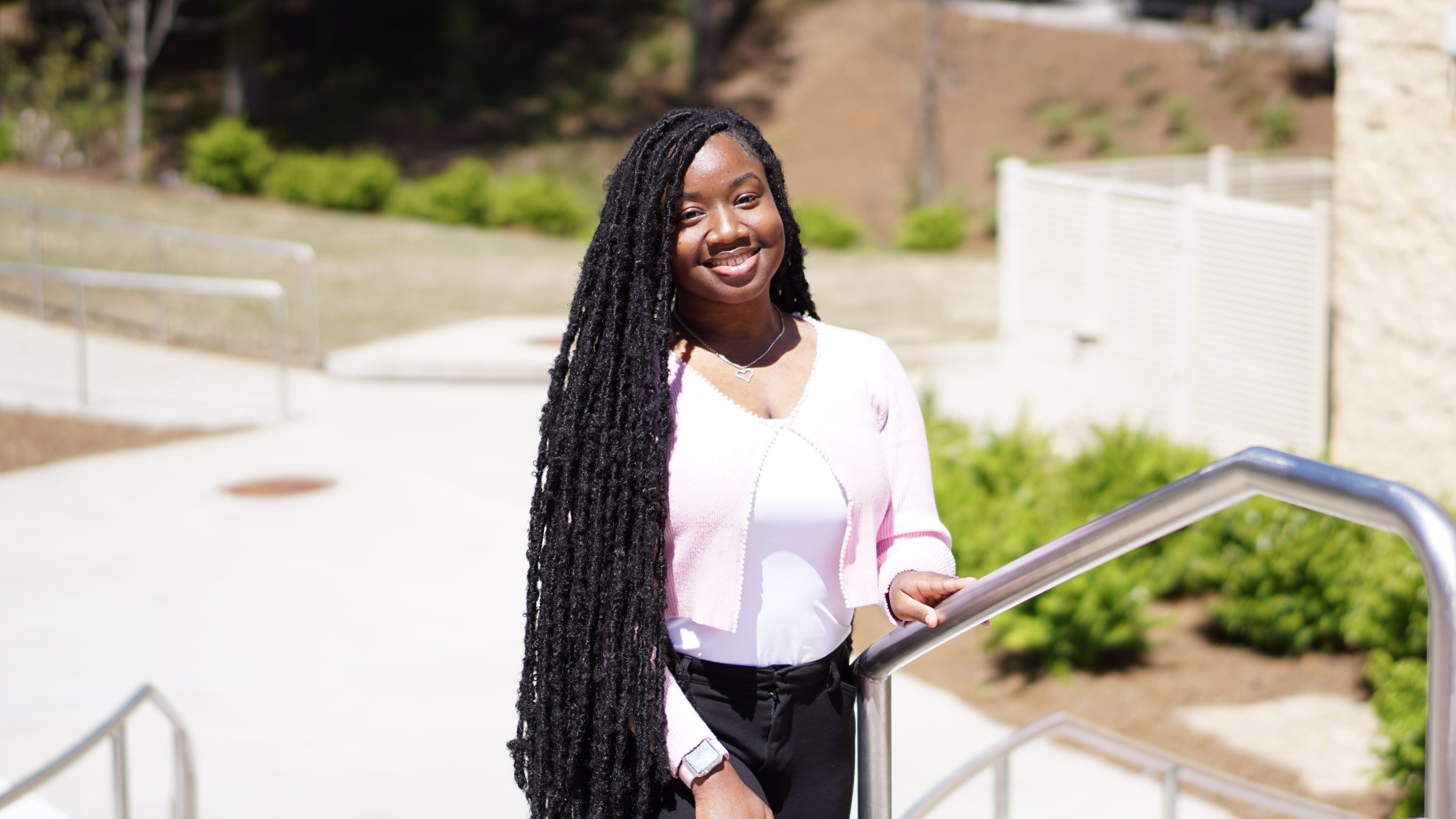 Student standing on steps outside of RCOB.